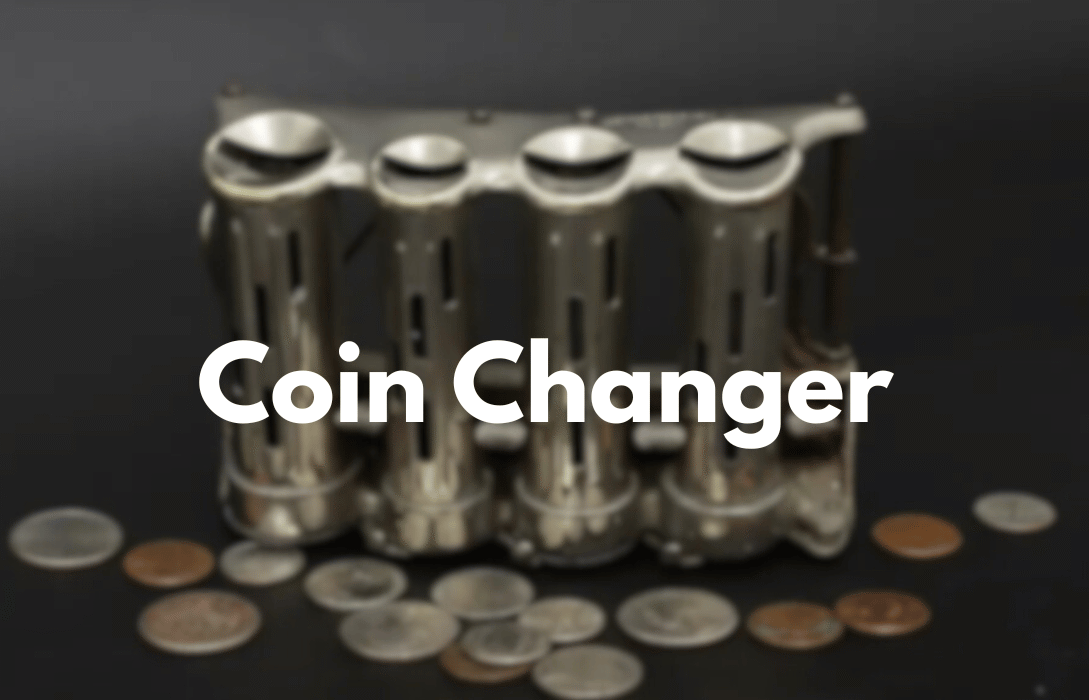 Vintage metal four-tube coin changer with coins.