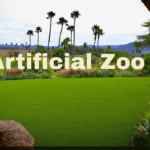 Artificial Zoo landscape with lush green grass and palms.