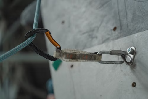 Action Sports OG60 Fluorescent Orange tether shown attached to climbing equipment.